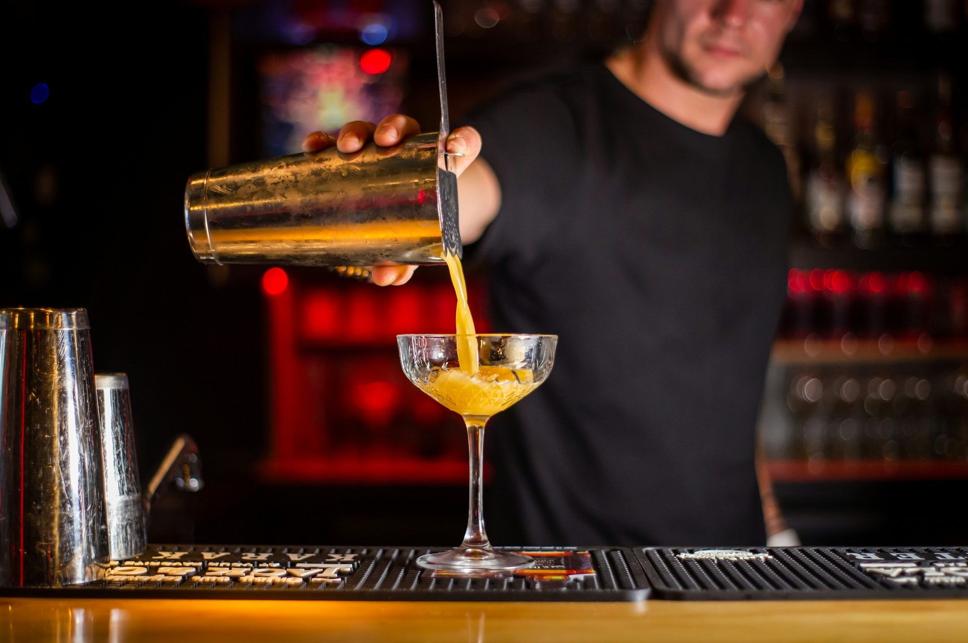 Barkeeper seiht einen Cocktail ab