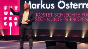 Markus Österreicher zeigt bei seiner Keynote „Was kostet schlechte Führung?“ ins Publikum